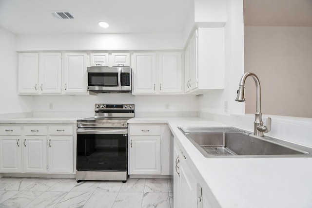 kitchen featuring sink, stainless steel appliances, and white cabinets