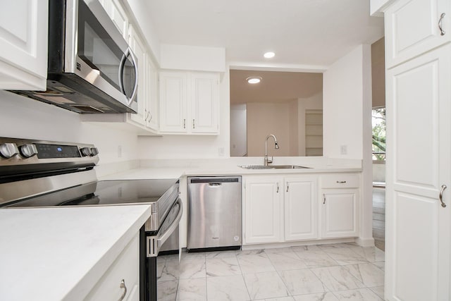 kitchen with sink, appliances with stainless steel finishes, and white cabinets