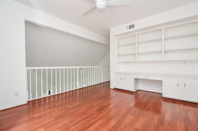 unfurnished office with ceiling fan, light wood-type flooring, and built in desk