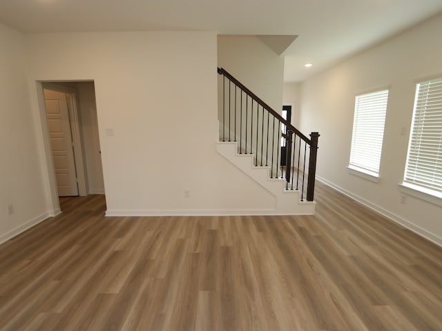 31907 Splendor Dr, Fulshear, TX 77441 - unfurnished living room with wood finished floors, stairs, baseboards, and recessed lighting