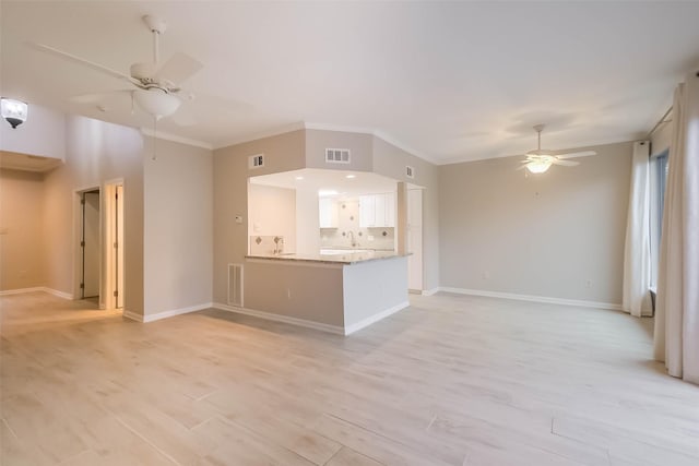 unfurnished living room featuring light wood-style floors, baseboards, visible vents, and a ceiling fan