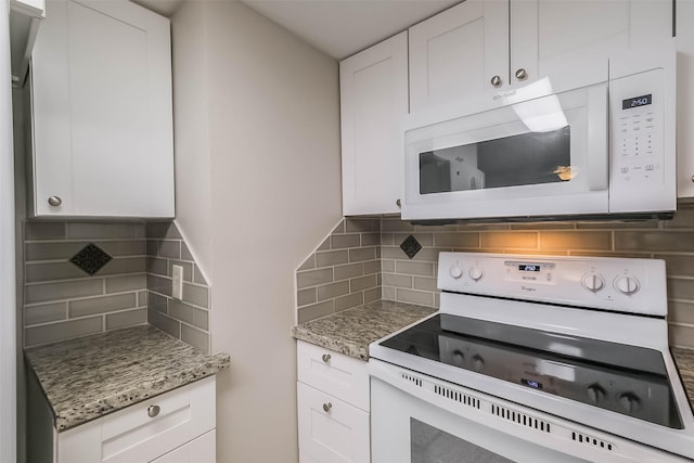 kitchen featuring light stone counters, white appliances, white cabinetry, and tasteful backsplash