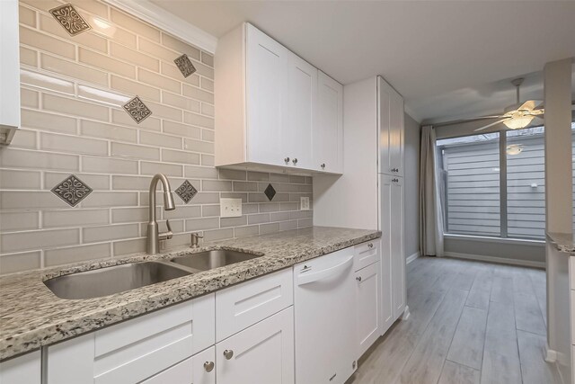 kitchen with decorative backsplash, white cabinets, a sink, ceiling fan, and dishwasher