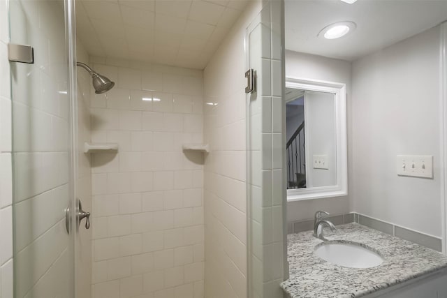 bathroom with a shower stall and vanity