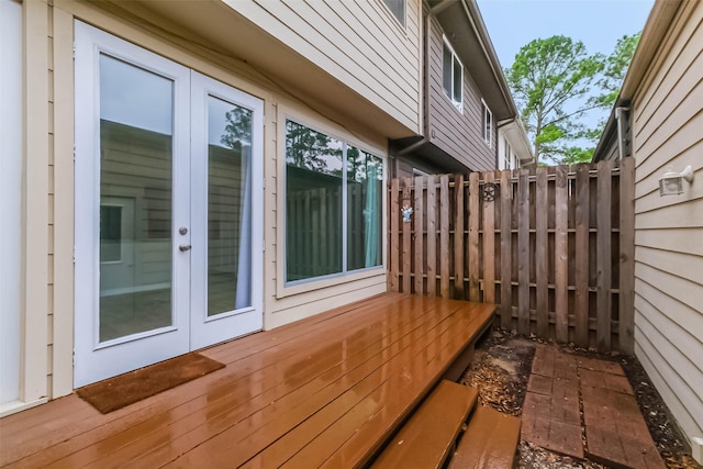 exterior space with french doors, a wooden deck, and fence