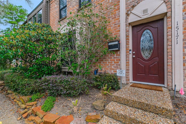 entrance to property featuring brick siding