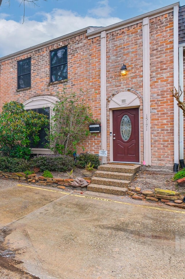 property entrance featuring brick siding