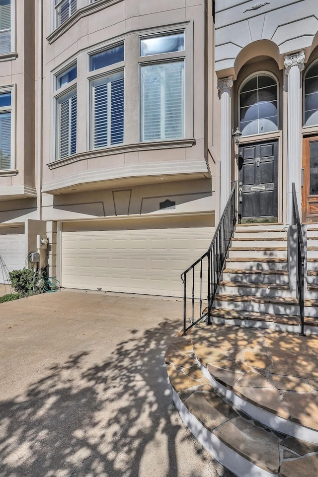 property entrance with a garage and driveway