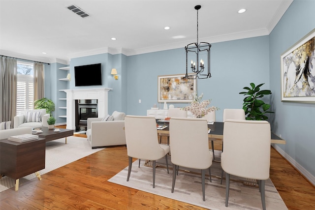 dining area with recessed lighting, wood finished floors, visible vents, ornamental molding, and a notable chandelier