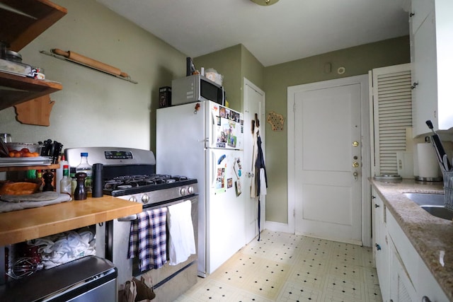 kitchen featuring white appliances, white cabinetry, and light floors