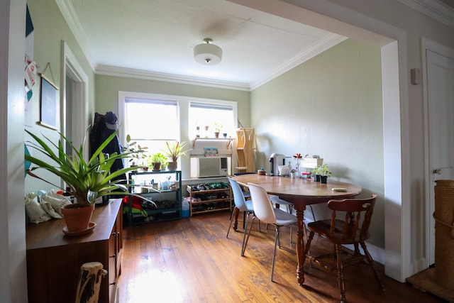 dining area with ornamental molding, cooling unit, and wood finished floors