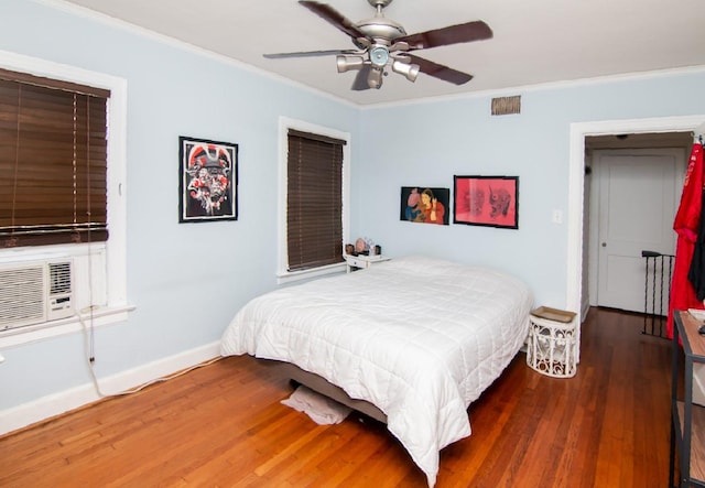 bedroom featuring visible vents, crown molding, and wood finished floors