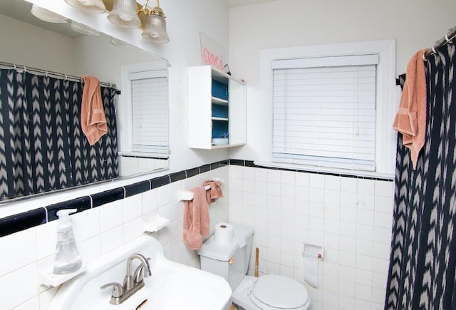 full bathroom with a shower with curtain, a sink, tile walls, and toilet