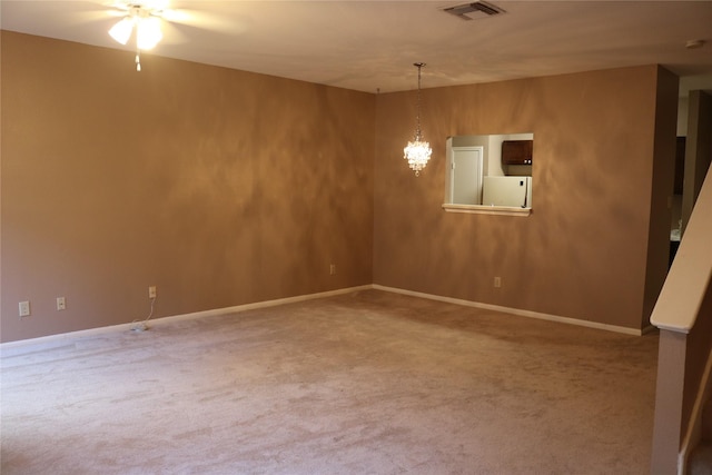 unfurnished room with carpet floors and a notable chandelier