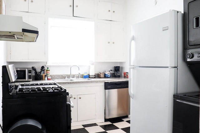 kitchen with under cabinet range hood, stainless steel appliances, light countertops, light floors, and white cabinetry