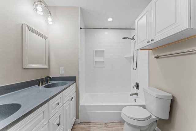 full bathroom featuring toilet, hardwood / wood-style flooring, tiled shower / bath, and vanity