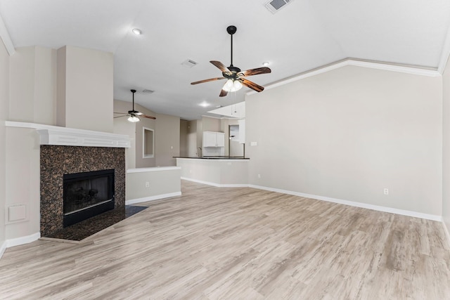 unfurnished living room featuring light wood-type flooring, lofted ceiling, and a tile fireplace