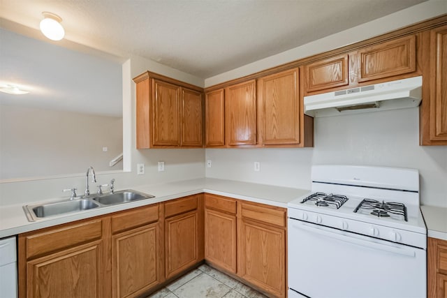 kitchen with white range with gas stovetop, light tile patterned floors, and sink