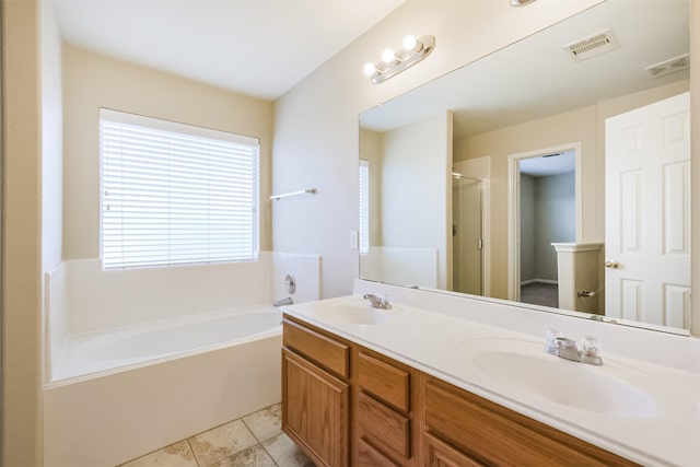 bathroom featuring tile patterned floors, vanity, and a bath