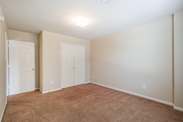 unfurnished bedroom featuring carpet, a closet, and a textured ceiling