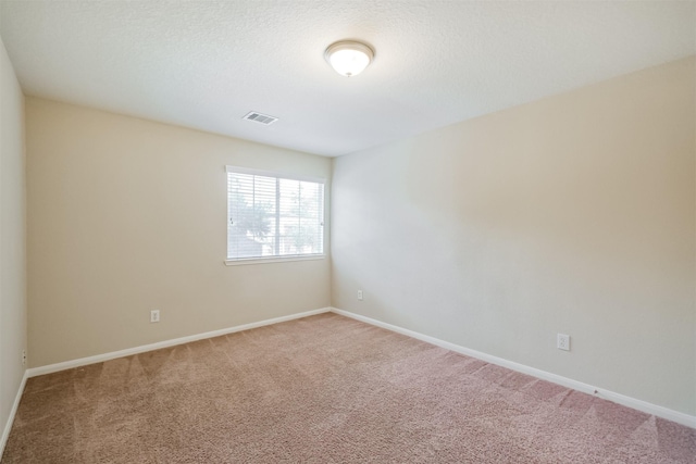 carpeted empty room with a textured ceiling