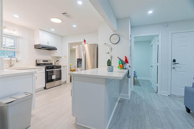 kitchen featuring white cabinets, appliances with stainless steel finishes, sink, and a kitchen island