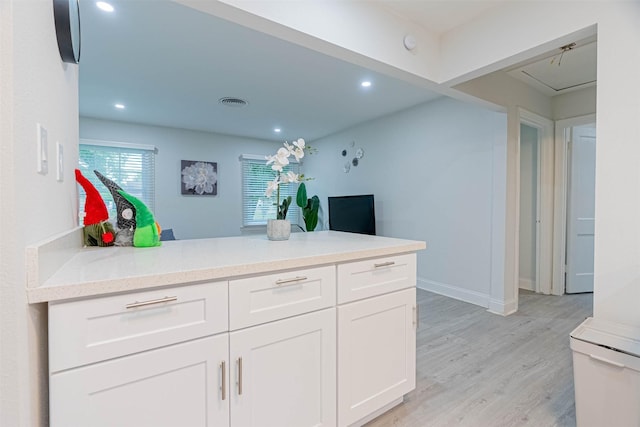 kitchen featuring white cabinetry, light stone counters, and light hardwood / wood-style flooring