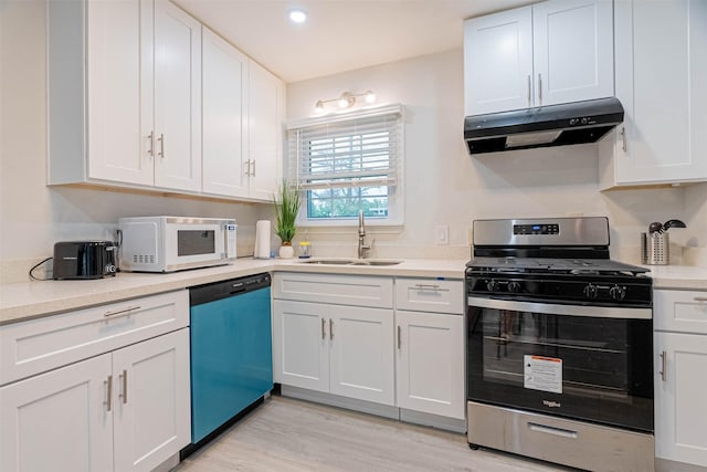 kitchen with appliances with stainless steel finishes, sink, and white cabinets