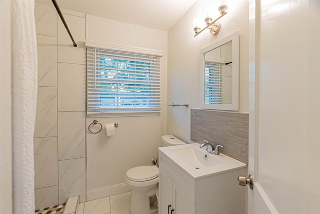 bathroom with toilet, tiled shower, tile patterned flooring, and vanity