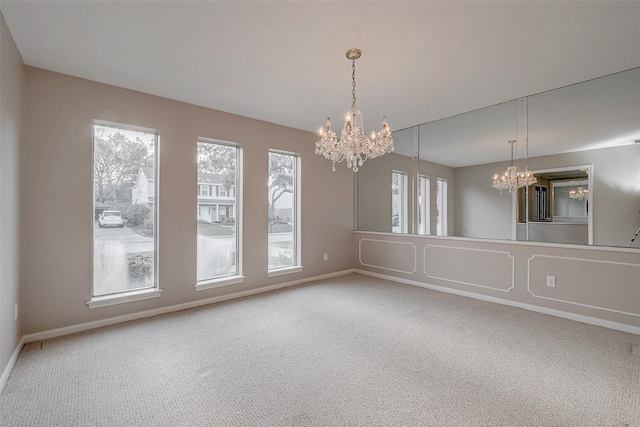 unfurnished room with a notable chandelier and carpet flooring