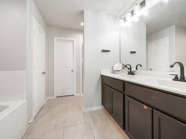 bathroom with a tub, tile patterned flooring, and vanity