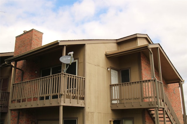 418 Garland Dr Unit 222, Lake Jackson, TX 77566 - back of house with brick siding, a chimney, and a balcony