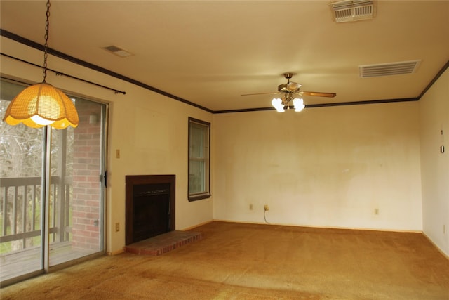 unfurnished living room with visible vents, a fireplace with raised hearth, carpet flooring, and ornamental molding