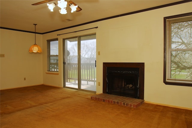 unfurnished living room featuring ceiling fan, carpet, crown molding, and a fireplace