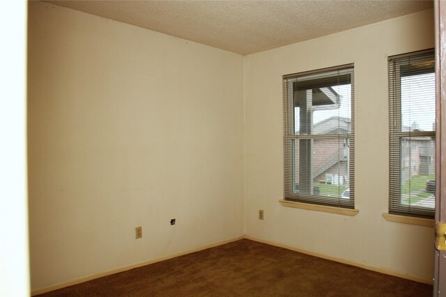 418 Garland Dr Unit 222, Lake Jackson, TX 77566 - unfurnished room with baseboards, dark colored carpet, and a textured ceiling