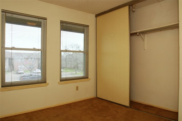 418 Garland Dr Unit 222, Lake Jackson, TX 77566 - unfurnished bedroom with a textured ceiling, baseboards, a closet, and carpet flooring