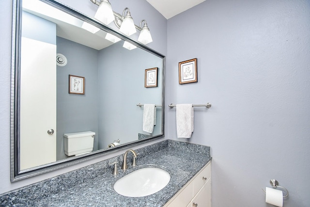 bathroom featuring toilet and vanity