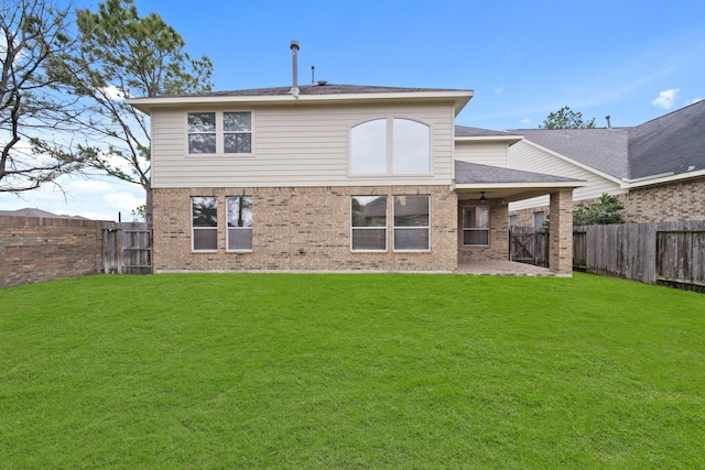 back of property with a yard, brick siding, a patio area, and a fenced backyard