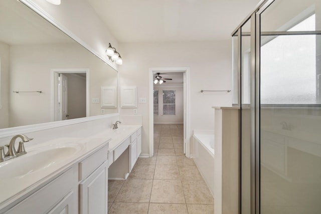 bathroom with tile patterned flooring, a garden tub, a sink, and double vanity