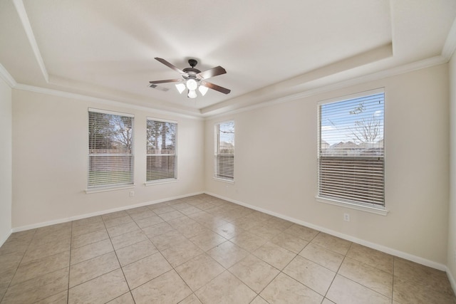 empty room with ornamental molding, a raised ceiling, ceiling fan, and baseboards