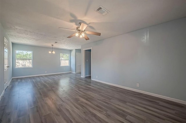 empty room featuring a textured ceiling, ceiling fan, and dark hardwood / wood-style floors