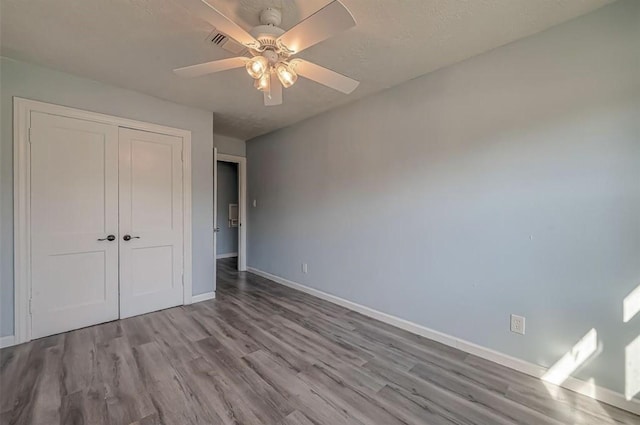 unfurnished bedroom featuring ceiling fan, light wood-type flooring, and a closet