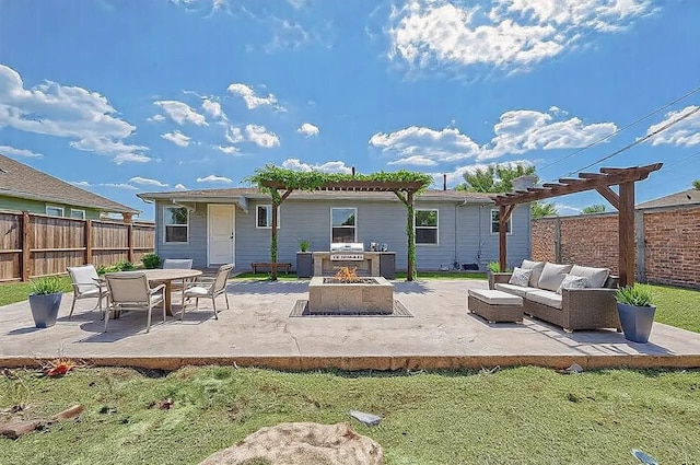 rear view of house with a patio area and an outdoor living space with a fire pit