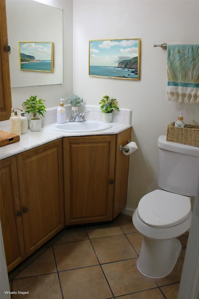 bathroom with toilet, tile patterned flooring, and vanity