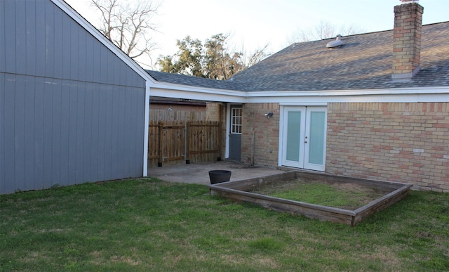 back of house with french doors, a lawn, and a patio area