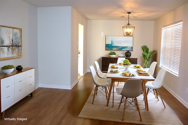 dining space featuring hardwood / wood-style floors, a notable chandelier, and plenty of natural light