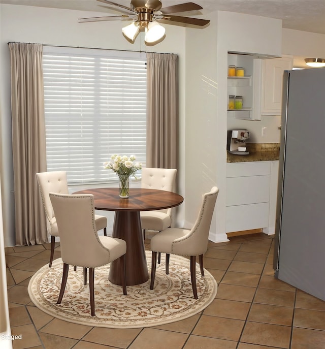 tiled dining area with ceiling fan