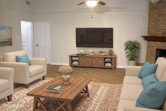 living room featuring a brick fireplace, ceiling fan, and tile patterned flooring