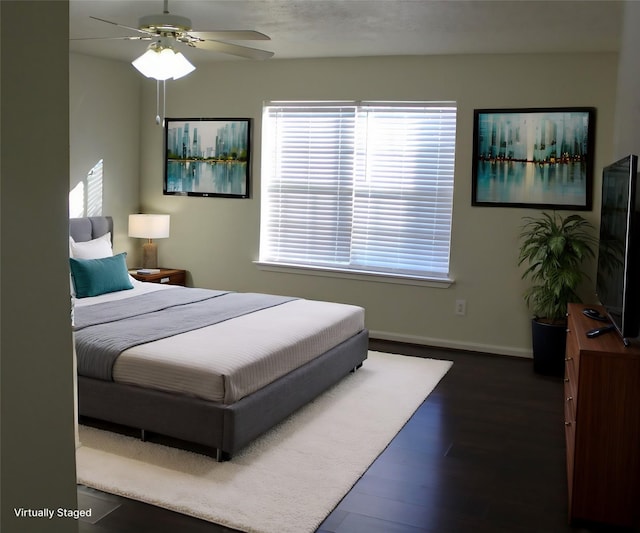 bedroom with ceiling fan and dark hardwood / wood-style floors