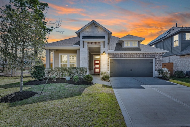 view of front of house featuring a garage and a lawn